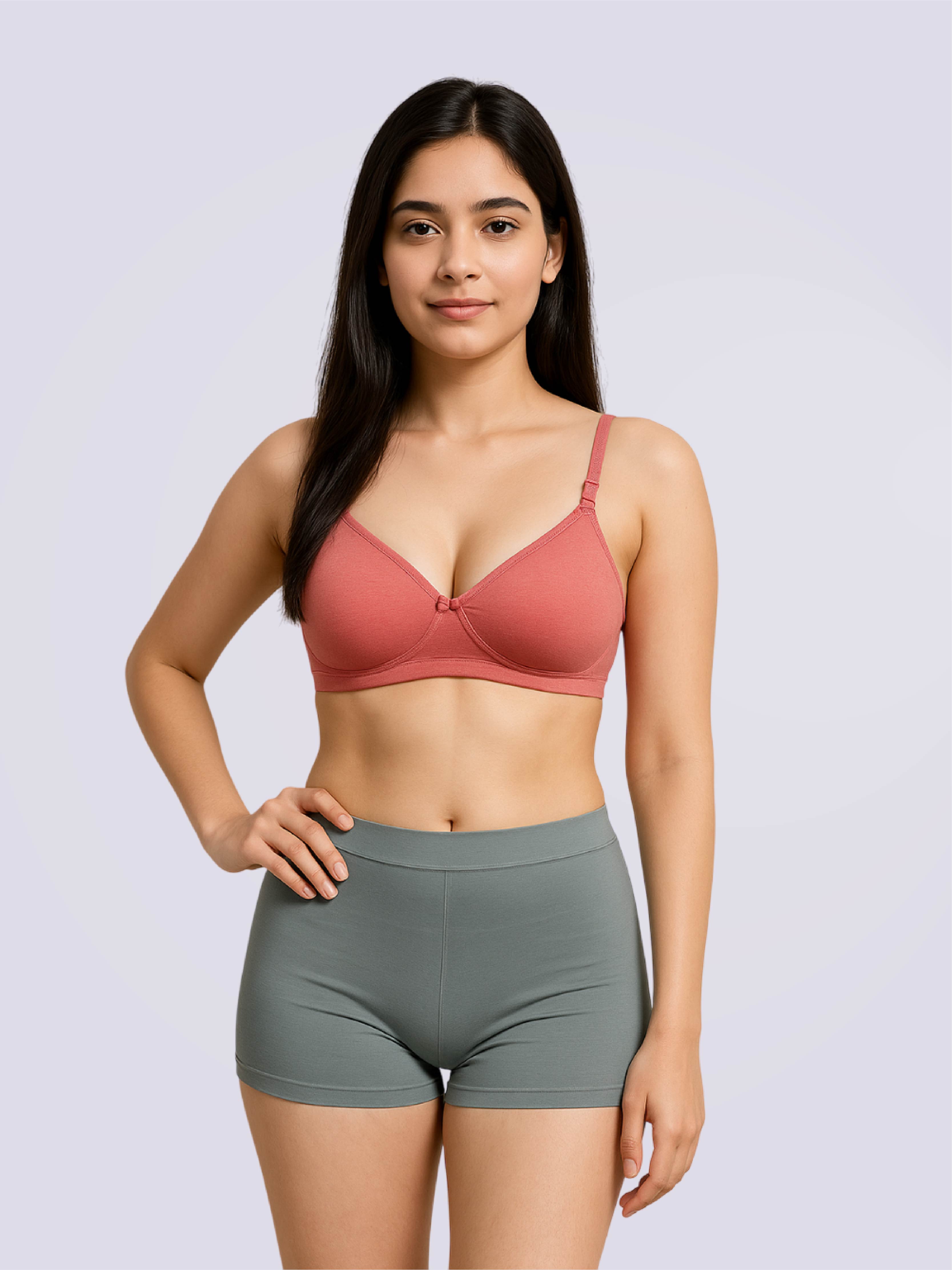 Woman wearing a pink bra and gray shorts on a light purple background